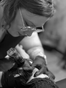 Raquel Tattoo tatuando un brazo en blanco y negro