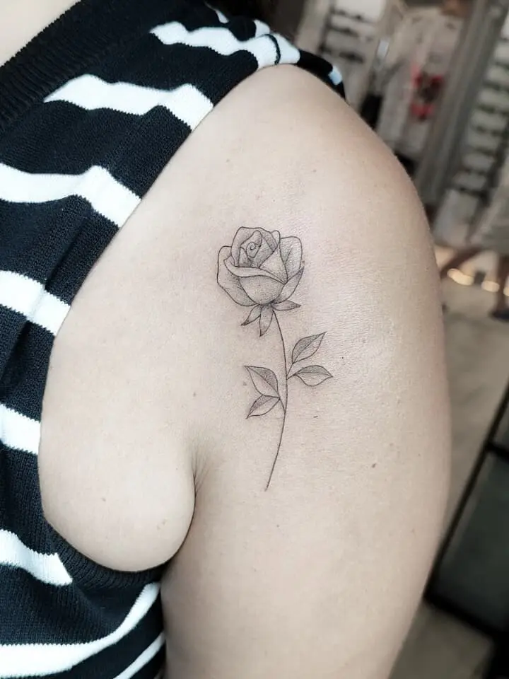 tatuaje fineline rosa minimalista en brazo