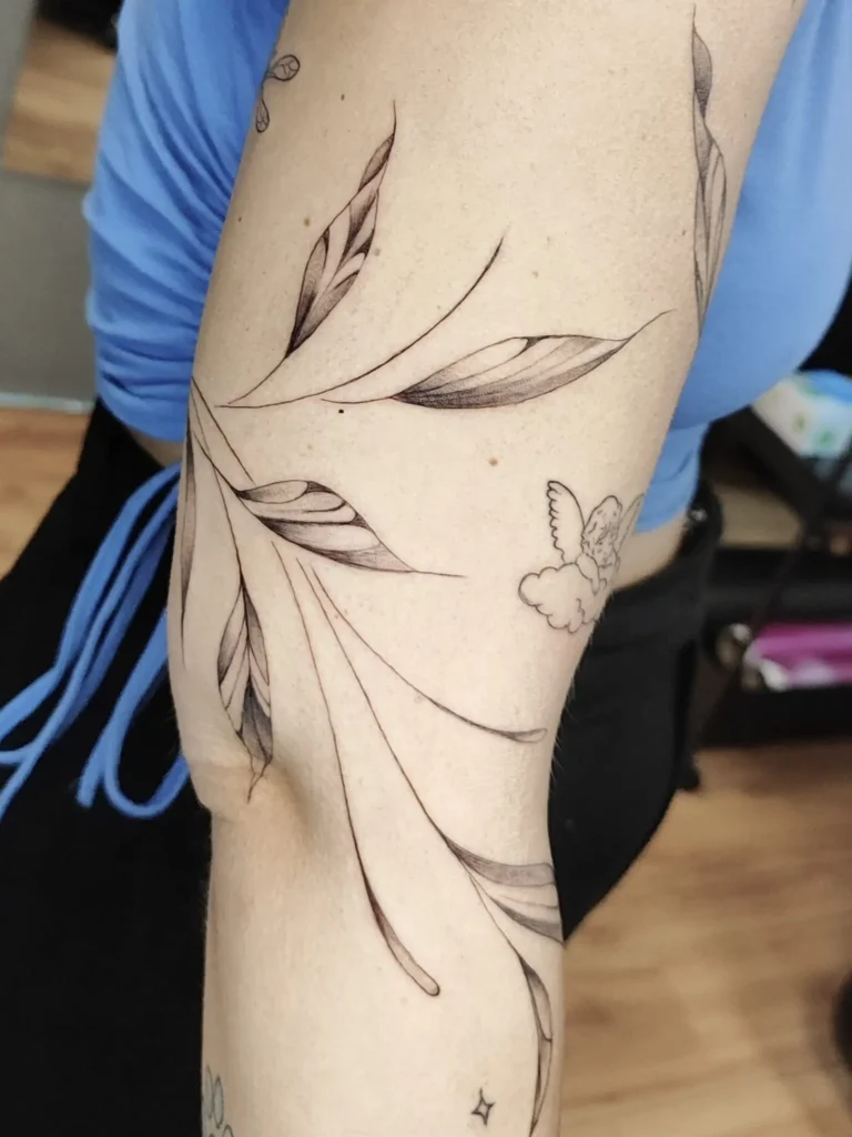 tatuaje botánico fineline de hojas en brazo