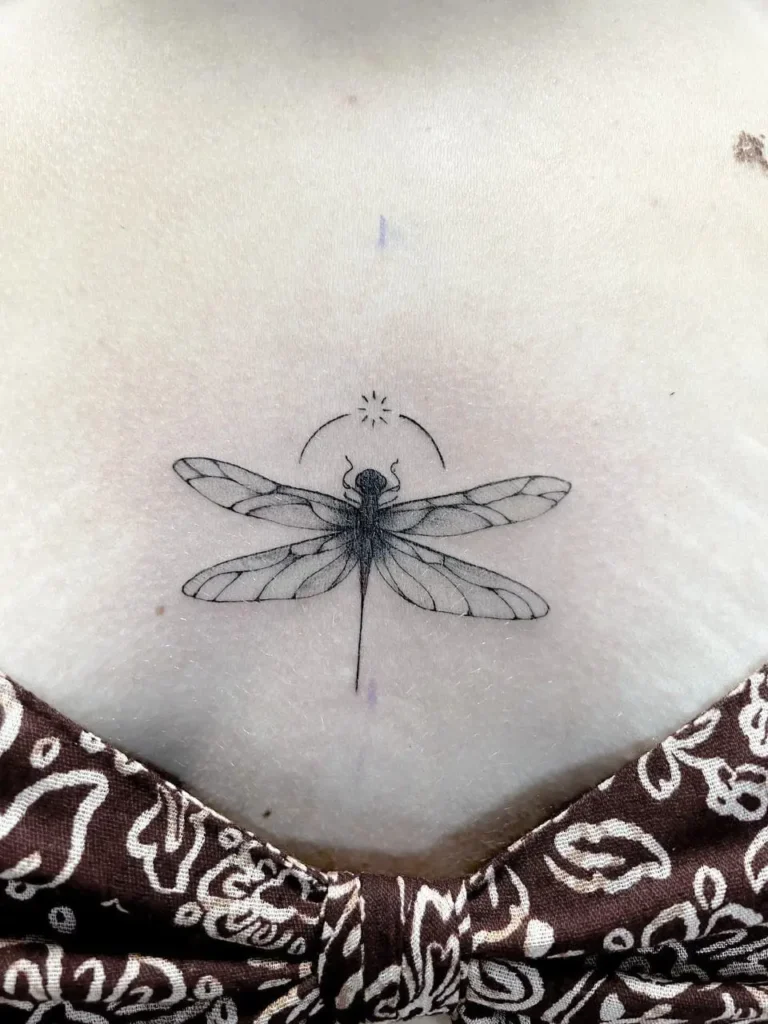 tatuaje libélula línea fina en pecho