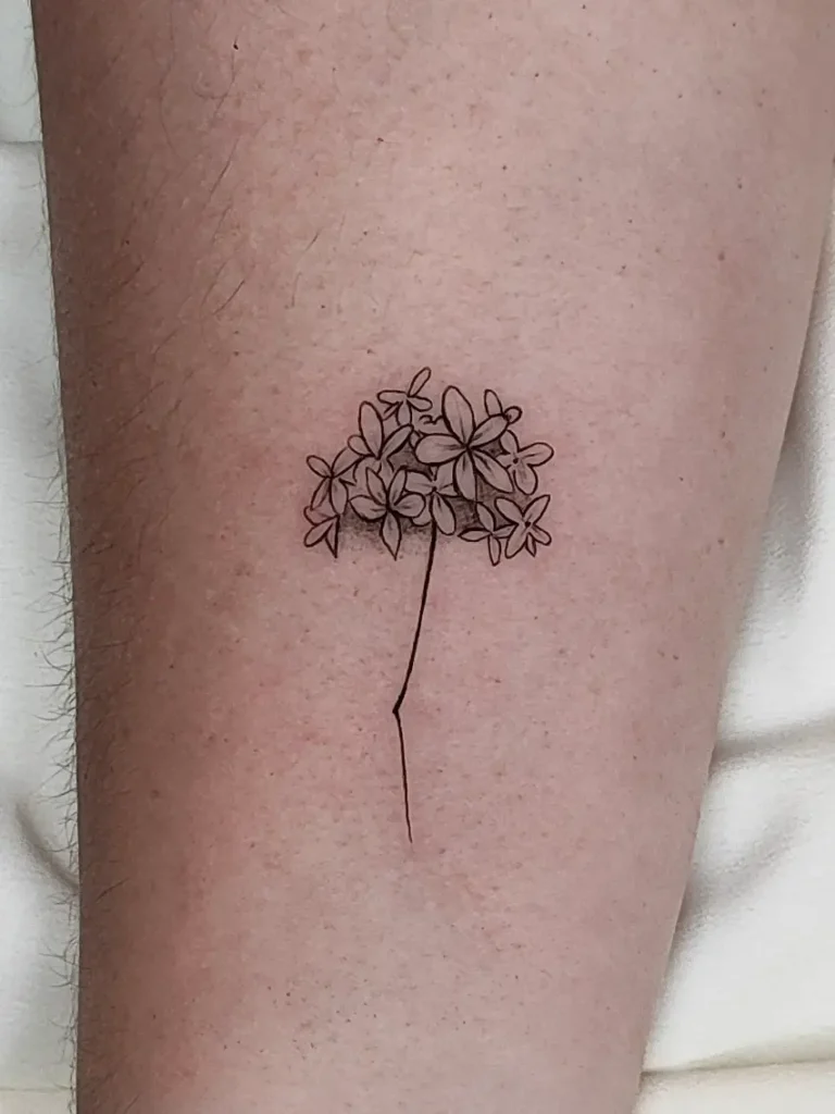 Biznaga de Málaga tatuada en línea fina en antebrazo