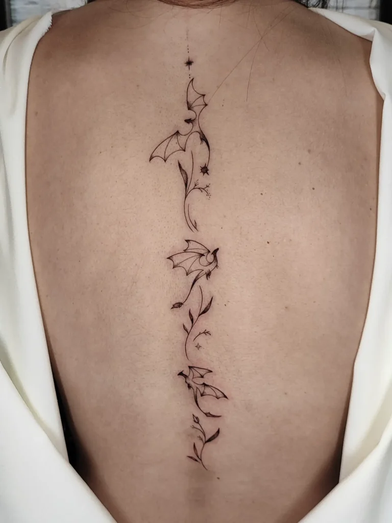 Tatuaje de dragones en la columna fineline